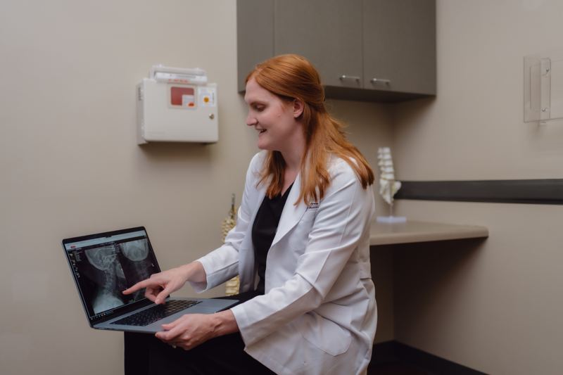 Dr. McShane reviewing spinal imaging on a laptop